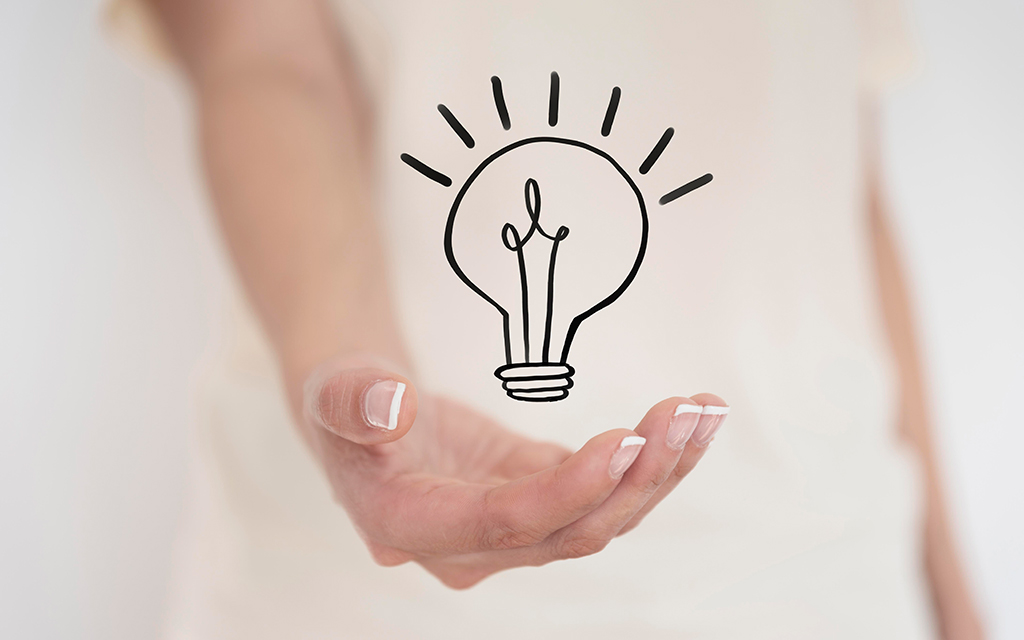 Open hand holding a simple line-drawn light bulb icon, symbolizing a new idea.